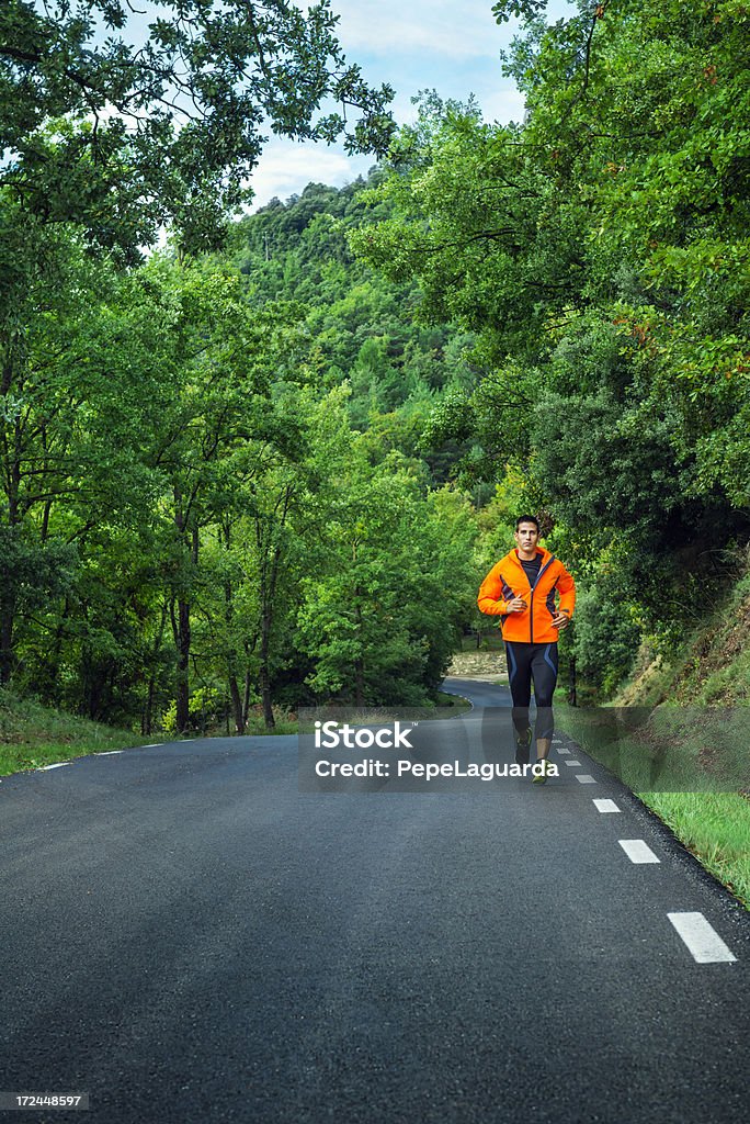 Healthy man jogging Healthy man jogging on a solitary road 30-39 Years Stock Photo