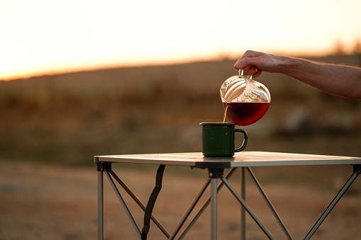 Brewing coffee in nature, in the evening sun