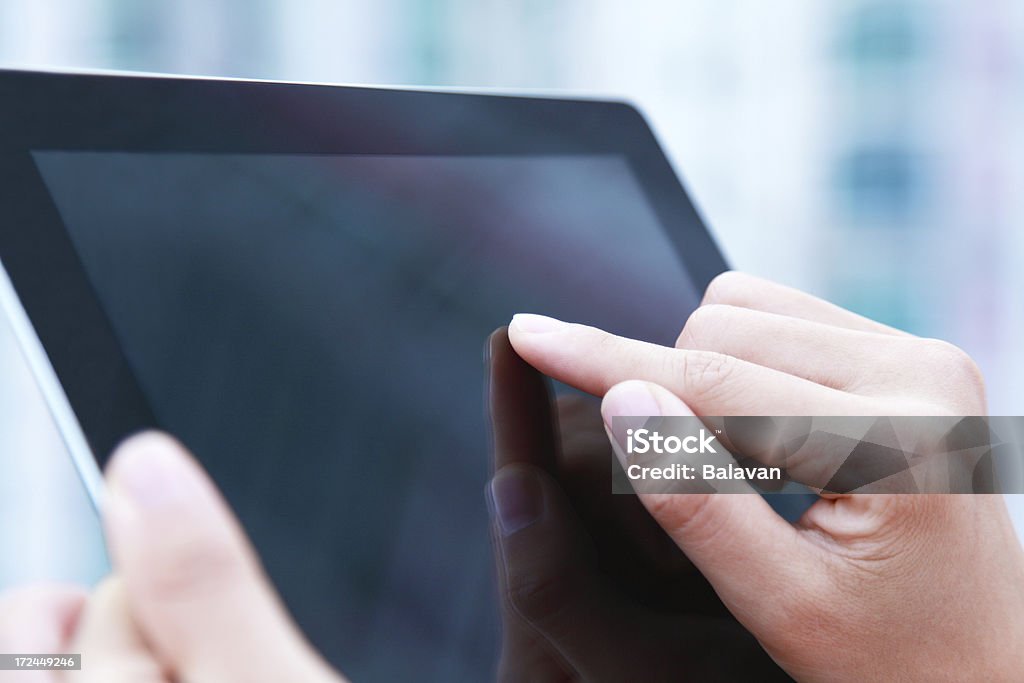 Las personas de negocios de Mano agarrando tableta digital sobre fondo azul claro - Foto de stock de Deslizar libre de derechos