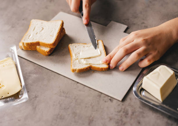 istock hands making a sandwich. preparing breakfast, putting cheese on toast bread. 1724495547