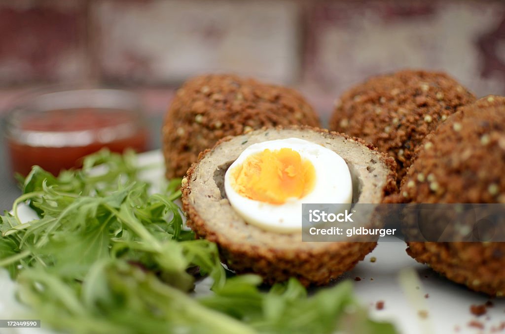 Home made scotch eggs "Free range eggs covered in pork meat with a breadcrumb coating, served with salad and a tomato dip." Egg - Food Stock Photo