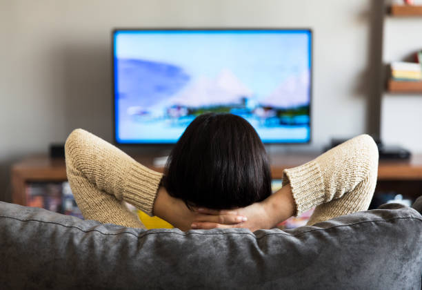 young woman watching television stock photo
