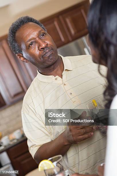 Senior African American Couple Having Discussion In Kitchen Stock Photo - Download Image Now