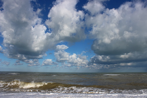 A pebble beach, particular clouds and sea, a beautiful natural landscape