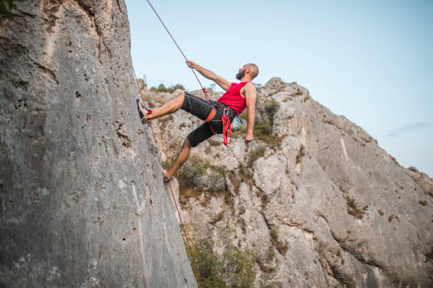 istock A focused man overcomes extremely steep terrain by climbing a mountain 1724527307