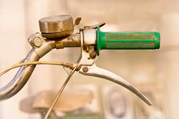 "Old Moped Handlebar with brake handle bicycle bell, seat defocused in background. Part of a German NSU Quickly Moped built in 1953. Selective focus.Time for something new."