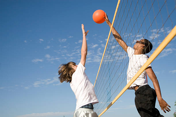 Two young males playing volleyball