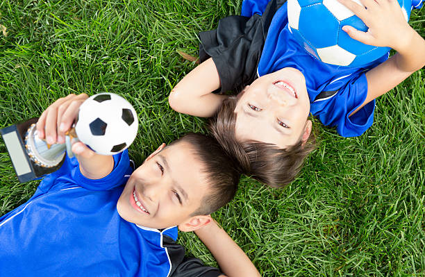 istock Siblings holding their soccer ball in the grass 172453781