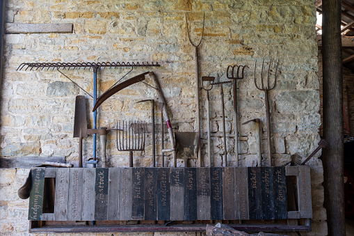 Photo of a selection of antique farm tools inside the barn atTyneham farm in Tyneham village in Dorset