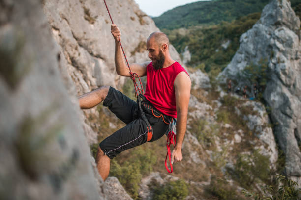 istock Bearded male climber climbs a mountain during the day on extreme terrain 1724541857