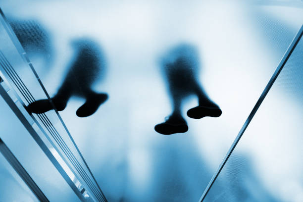 Silhouette people on glass staircase