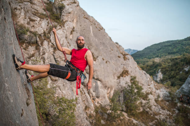 istock Climber man overcomes extremely steep terrain by climbing a mountain during the day 1724544066