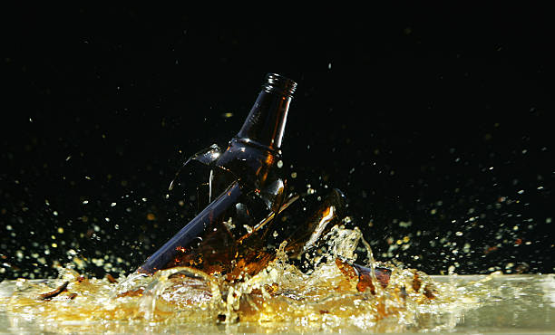 smashing botella de cerveza - glass broken spilling drink fotografías e imágenes de stock