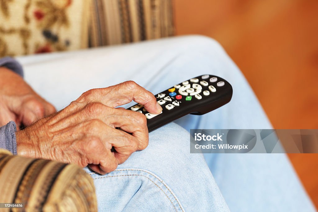 Uomo anziano mano con telecomando TV - Foto stock royalty-free di Telecomando