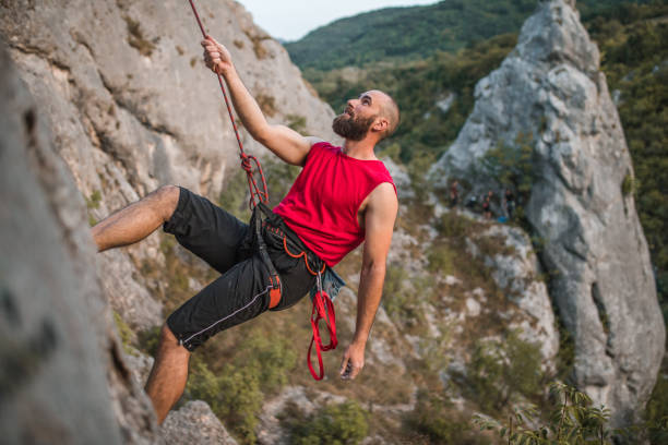 istock Man climber climbs a mountain during the day on extreme terrain 1724547060