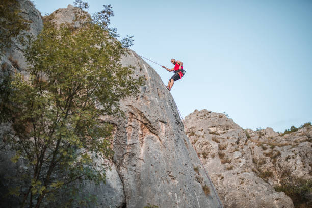 istock Man climber overcomes extremely steep terrain by climbing a mountain 1724547124