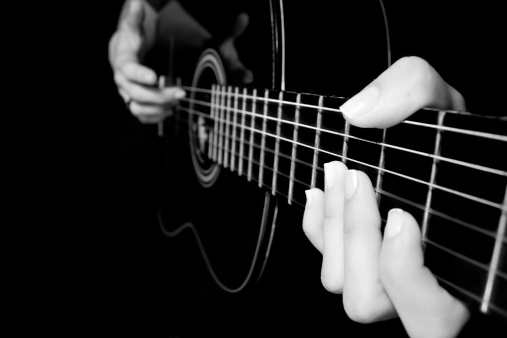 Close-up of man's hands playing bass guitar. Person playing bass guitar. Guitar strings. Person playing rock. Musical instrument