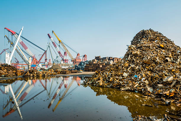 Giant cranes load steel onto a waiting ship at a shipyard.