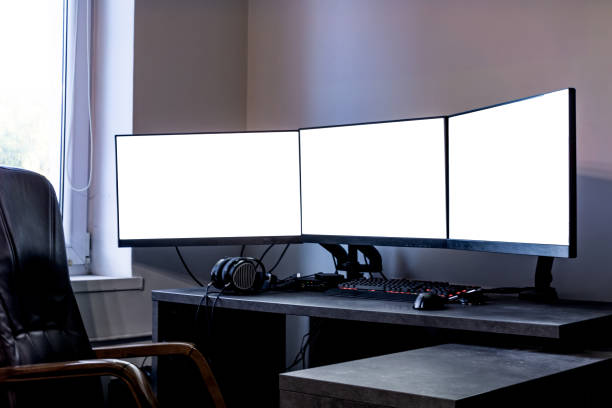 istock tree empty monitors mock-up on a desk next to a window and a chair headphones, keyboard, mouse, and tablet 1724554591