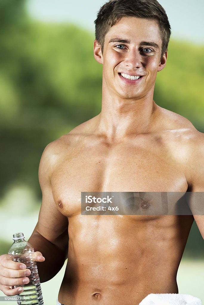 Muscoloso uomo che tiene un waterbottle - Foto stock royalty-free di A petto nudo