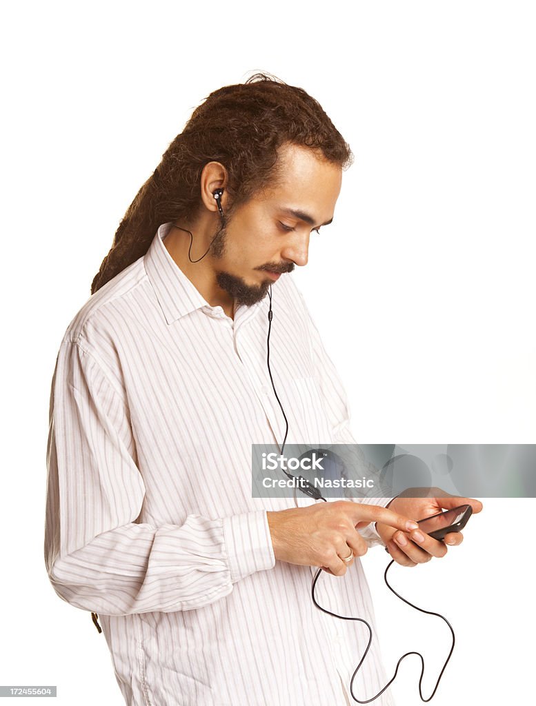 Casual giovane uomo ascolta la musica con il suo telefono cellulare - Foto stock royalty-free di Abbigliamento casual