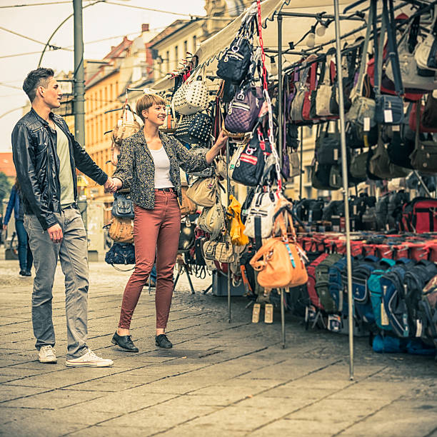 paar im market wählen sie eine tasche - berlin germany germany urban scene shopping bag stock-fotos und bilder