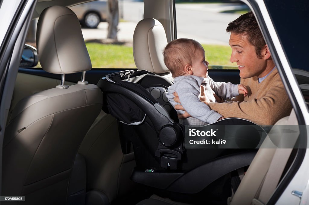 Père putting bébé dans un siège de voiture - Photo de Voiture libre de droits