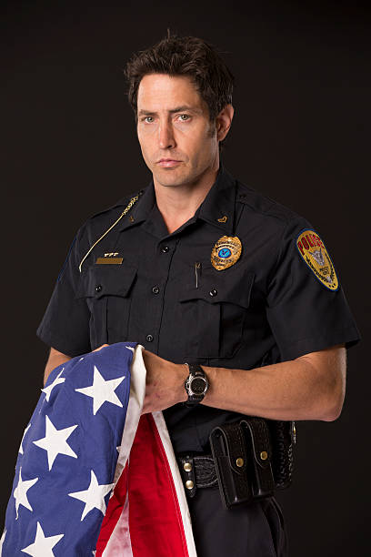 istock Policeman holding an American Flag 172455991