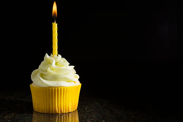 Lemon-Lime Cupcake with Candle on Black stock photo