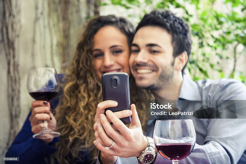 Пара, улыбающихся во время размещения фото в социальных сетях - Стоковые фото Алкоголь - напиток роялти-фри