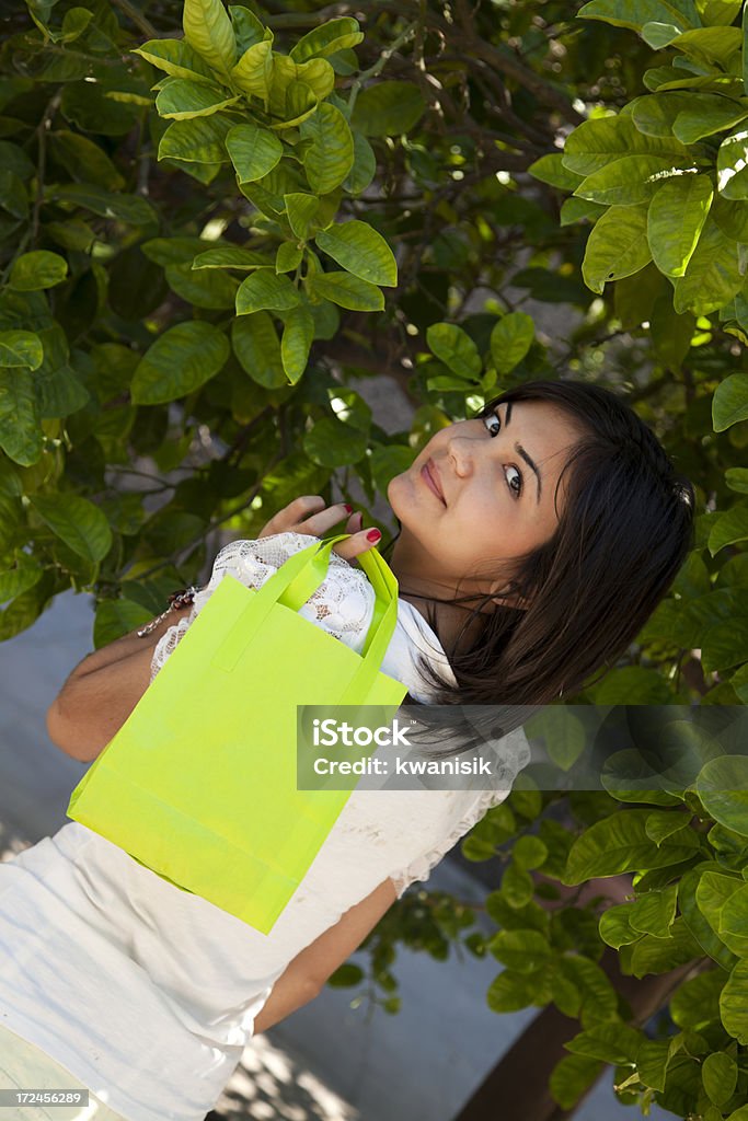 Молодая девушка и зеленая сумка для покупок - Стоковые фото 20-29 лет роялти-фри