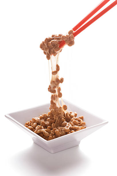 Natto Falling From Chopsticks Natto is a Japanese dish made from fermented soybeans. It has a distinctive smell and sticky, stringy texture. natto stock pictures, royalty-free photos & images
