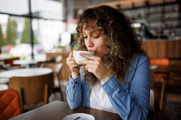 istock Young woman enjoying coffee at a cafe 1724565249