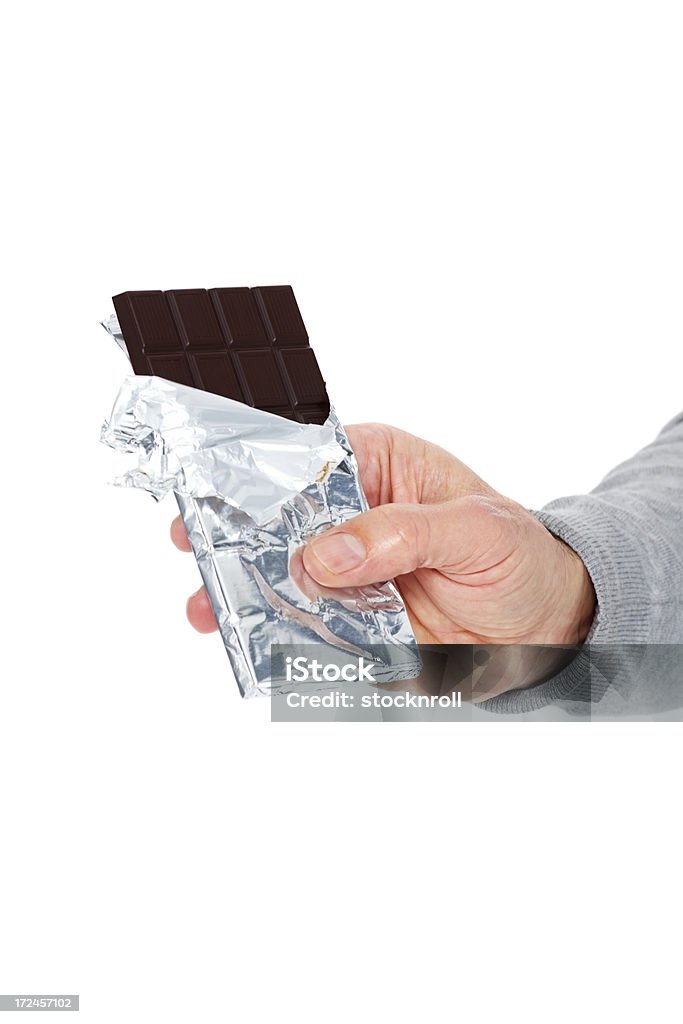 Homme de main tenant une barre chocolatée contre blanc - Photo de Chocolat libre de droits