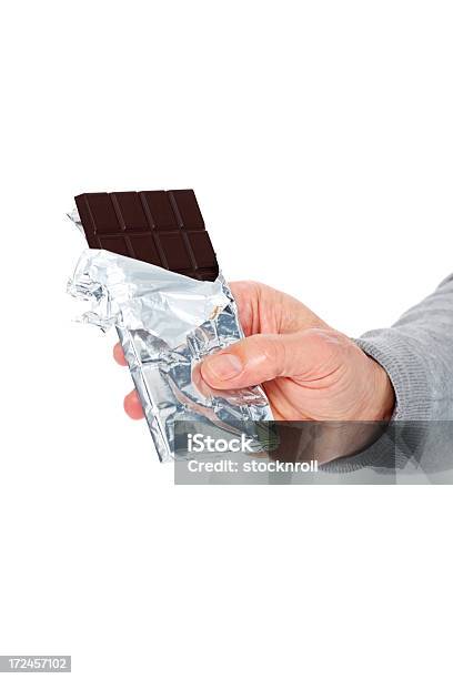 Foto de Homem Mão Segurando Uma Barra De Chocolate Contra Branco e mais fotos de stock de Chocolate