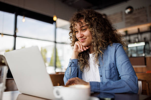 Young woman working on laptop at a cafe
