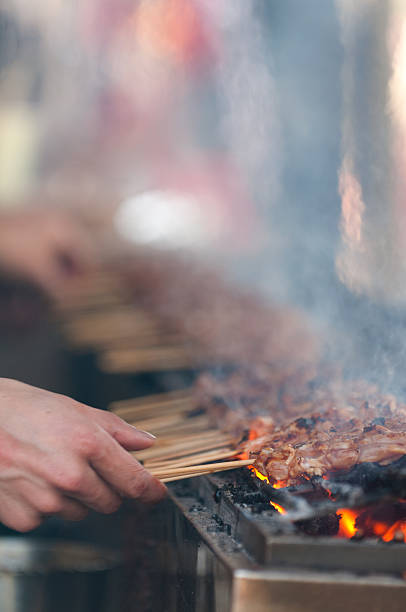 istock Hand Turning Barbequed Chicken Skewers on a Grill 172457639