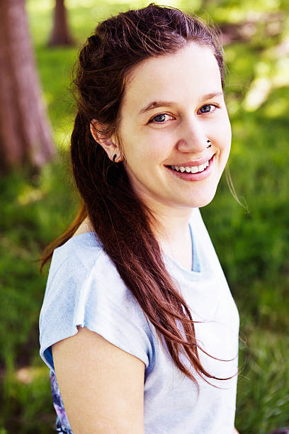 istock Pretty woman sitting under tree smiles gently 172457678