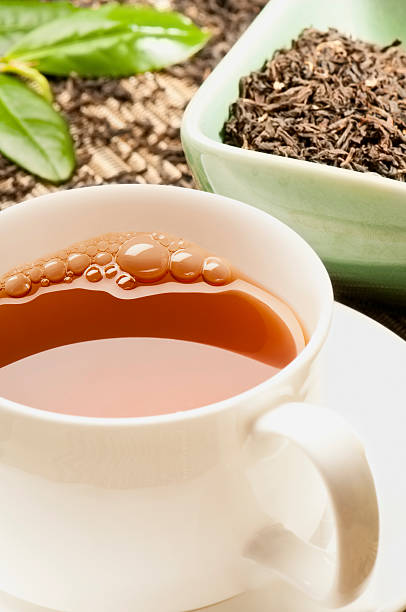 istock Assam tea and tea leaves in white cup and saucer 172457865
