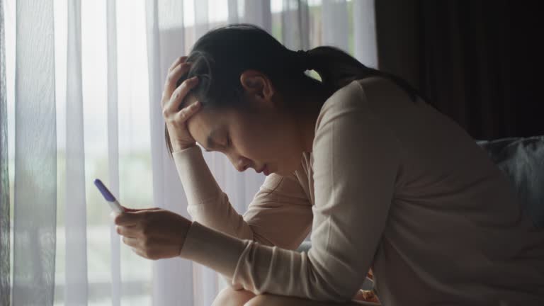 Young woman looking upset after taking a pregnancy test at home