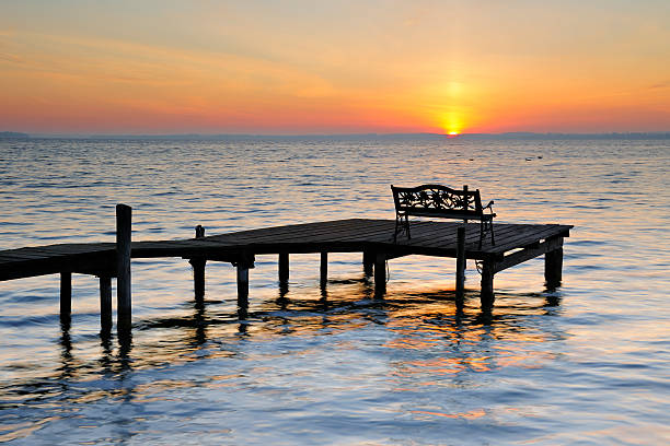 istock Bench on Dock by Lake at Sunrise 172458285
