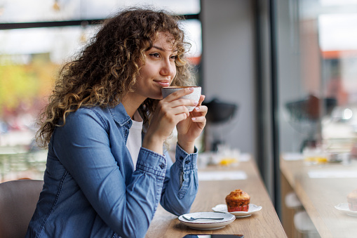 Young woman drinking coffee in a coffee shop