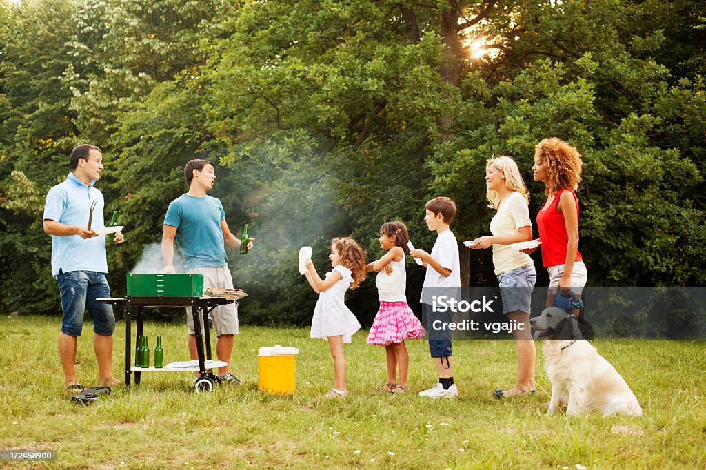 Familias disfrutando de una barbacoa. - Foto de stock de Barbacoa - Comida libre de derechos