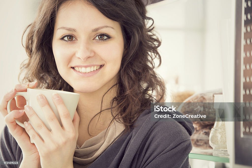 Bellissimo Ritratto di ragazza in cucina con il cellulare - Foto stock royalty-free di Adulto