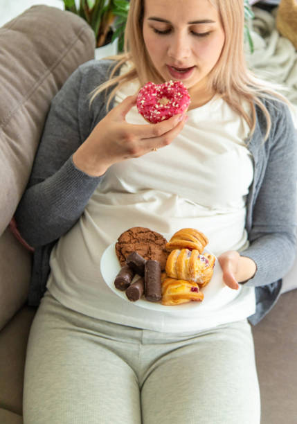 istock A pregnant woman eats a sweet donut. Selective focus. 1724604185