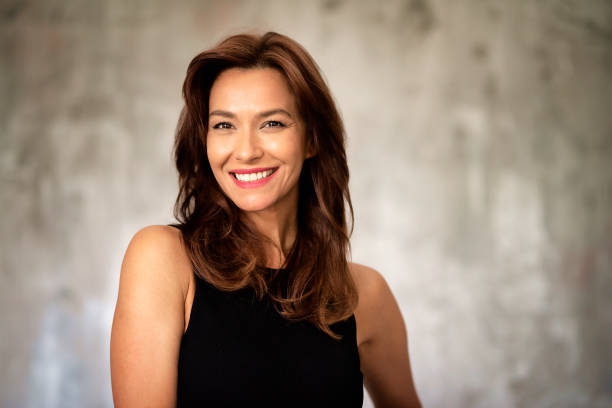 istock Attractive mid aged woman cheerful smiling against grey wall 1724604286