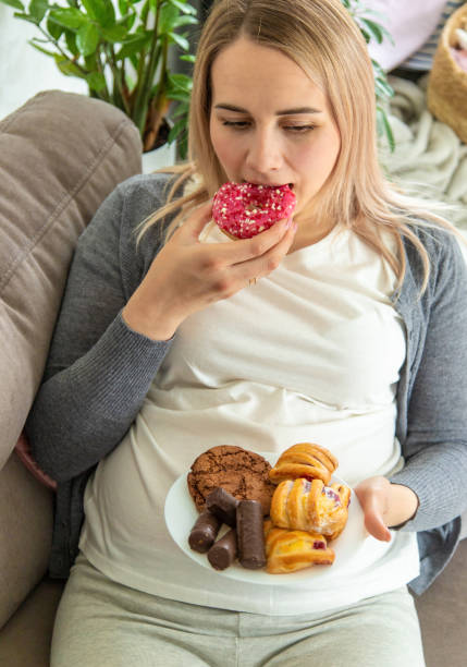istock A pregnant woman eats a sweet donut. Selective focus. 1724604288