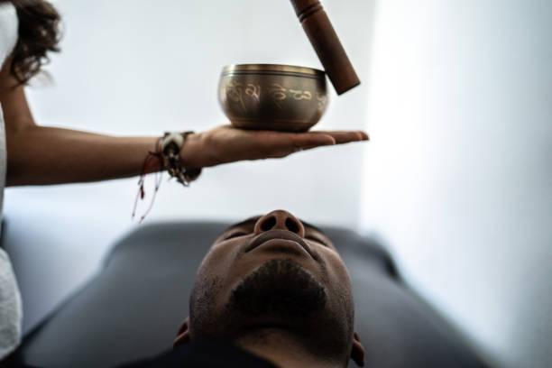 Therapist playing rin gong while performing music therapy at spa