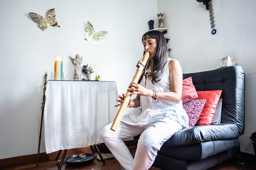 Holistic therapist woman playing flute