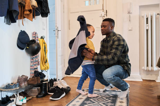 Father dressing up son before going out of house